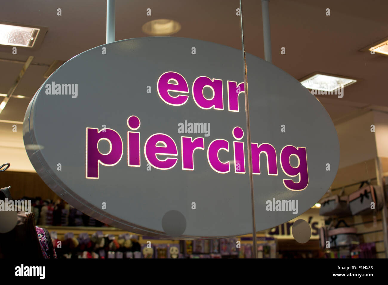Ear piercing sign in Claire`s Accessories shop, Stratford-upon-Avon, UK Stock Photo